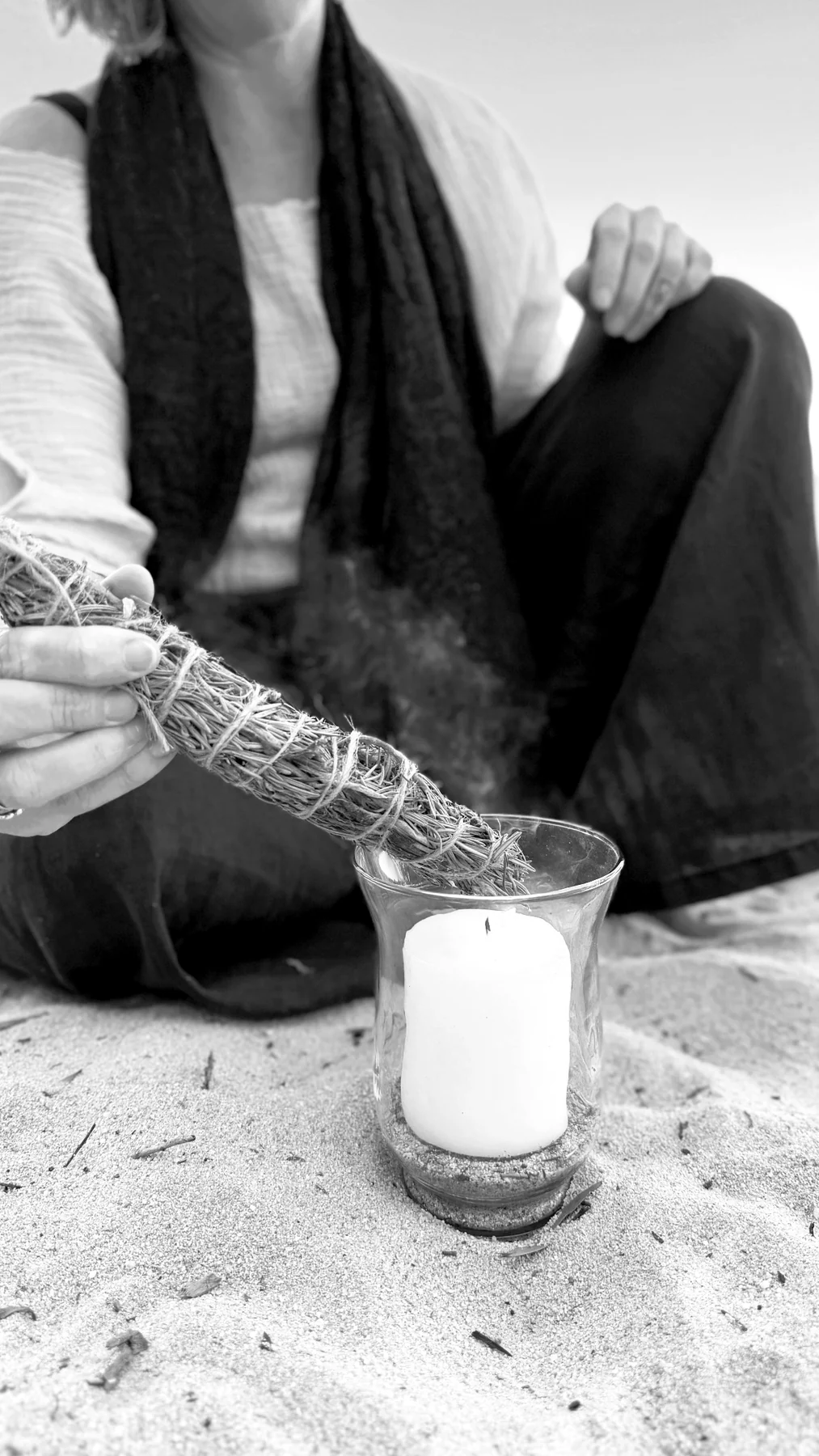 A candle and smudge stick arranged for a quiet ritual