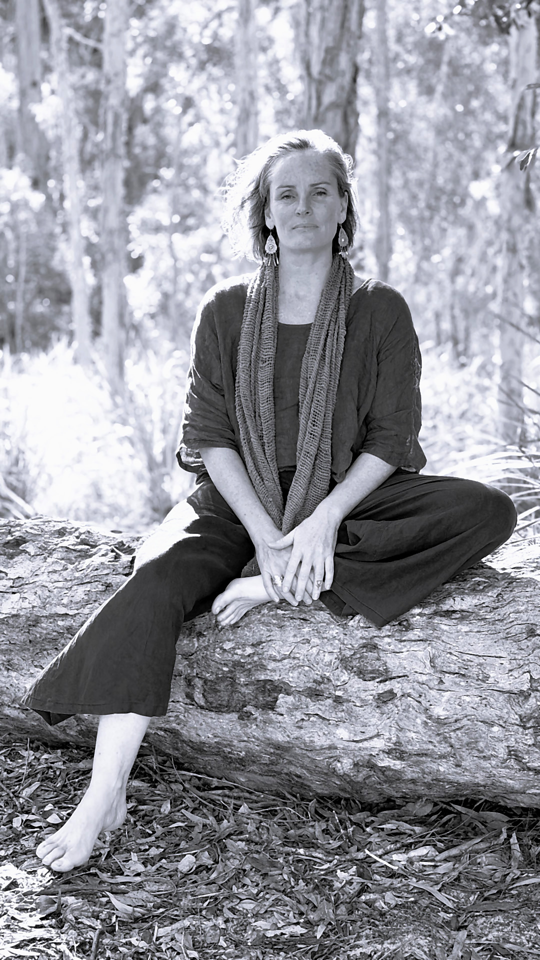 Jaime-Lee Hind seated on a fallen tree in native bushland